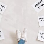 Habits - Person Legs with Motivational Words on Papers on White Background